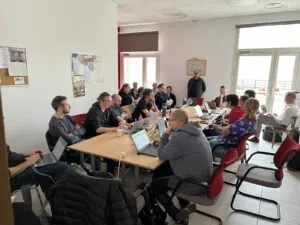 A room full of developers sitting at a large table working together.